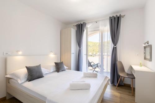 Un dormitorio blanco con una cama grande y una ventana. en Maloa One Bedroom 2, en Smokvica