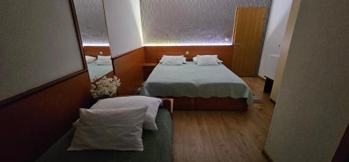 a small room with a bed and a mirror at SOBE/ROOMS RIVA in Zadar