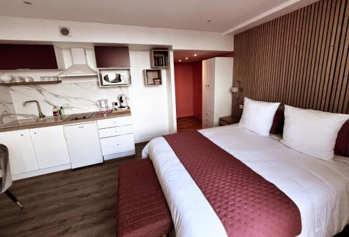 une chambre avec un grand lit et une cuisine dans l'établissement Studio L' Horizon, à Dunkerque