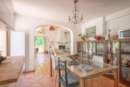 une salle à manger avec une table et des chaises en verre dans l'établissement Les Restanques de Bibémus, à Aix-en-Provence