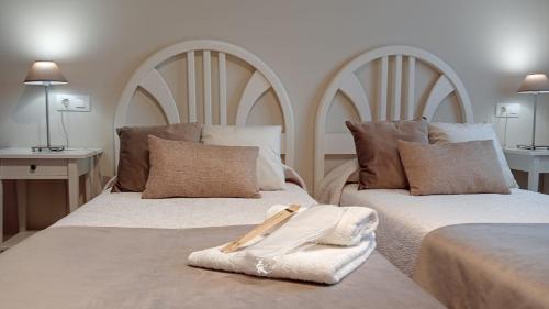 a bedroom with two beds with towels on them at Apartamentos La Blanca in Nueva de Llanes