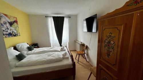 a bedroom with a bed with white sheets and a window at Gasthof Zur Post - Inning in Inning am Ammersee