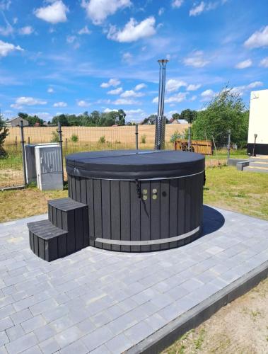 a fire pit with two benches in a park at OZZI LAND Resort in Sobącz