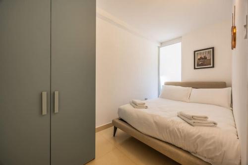 a white bedroom with a bed and a closet at New exquisite apt close to the beach by SF Homes in Sliema