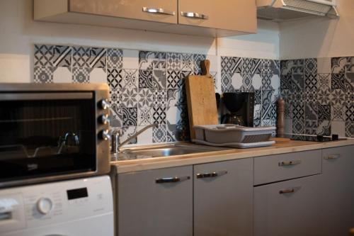 une cuisine avec un évier et un plan de travail dans l'établissement Fisherman's House Cozy Duplex, à Argenton-sur-Creuse