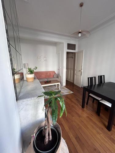 un salon avec une table et une plante en pot dans l'établissement Logement Paris Centre - Amazing Flat Saint Martin, à Paris
