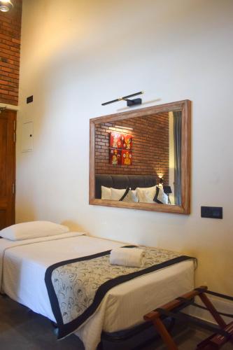 a bedroom with two beds and a mirror at Abhaya Mandapa in Anuradhapura