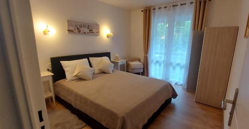 une chambre avec un lit et une grande fenêtre dans l'établissement Nouvel Appartement à 10mn à pied du Centre-Ville, à Albi