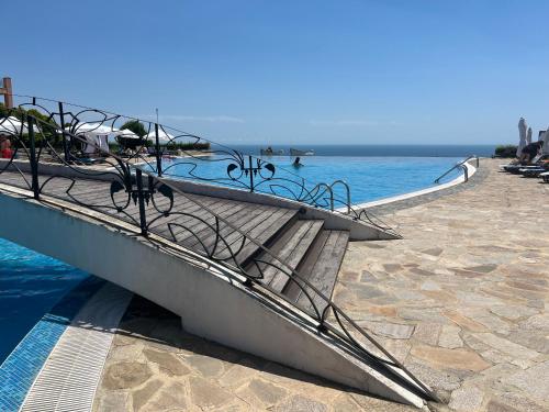a swimming pool next to a body of water at Kaliakria Vibes studio apartment in Topola