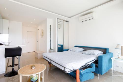 - une chambre avec un lit bleu et une table dans l'établissement Cannes-vue mer Esterel-balcon-Plage, à Cannes