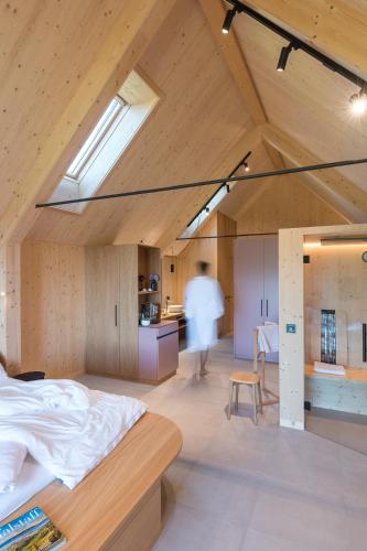 a room with a bed and a person in a kitchen at SCHILCHERLANDLEBEN - Hochgrail in Greisdorf