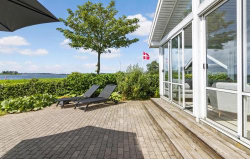 a patio with two chairs and an umbrella on a house at 2 Bedroom Nice Home In Kerteminde in Kerteminde