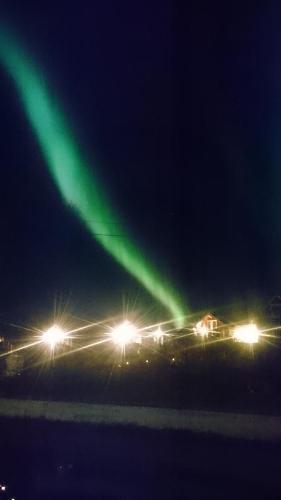 ein grünes Licht am Himmel in der Nacht in der Unterkunft Hammerstad Camping in Svolvær