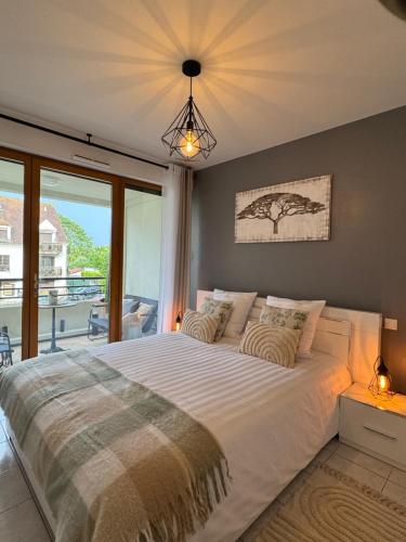 a bedroom with a large bed with a large window at Appart-VictoriaParis in Houilles