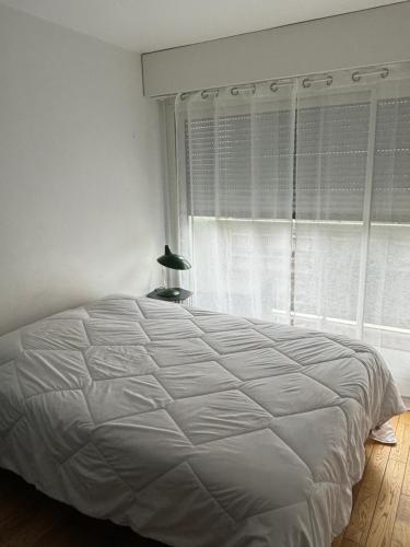 - un lit blanc dans une chambre avec fenêtre dans l'établissement T2 Boulogne Billancourt, à Boulogne-Billancourt
