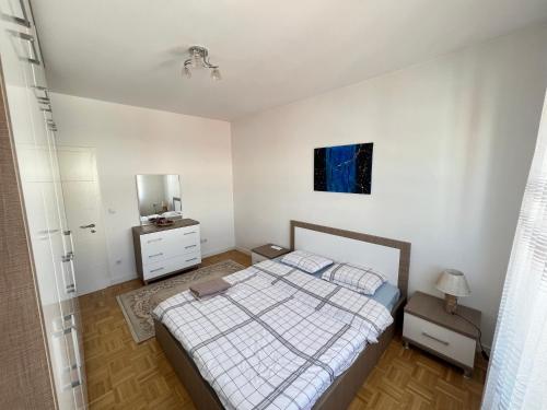 une chambre avec un lit, une commode et un miroir dans l'établissement J&D Apartment Prishtina - 1 double & 2 single beds, à Pristina