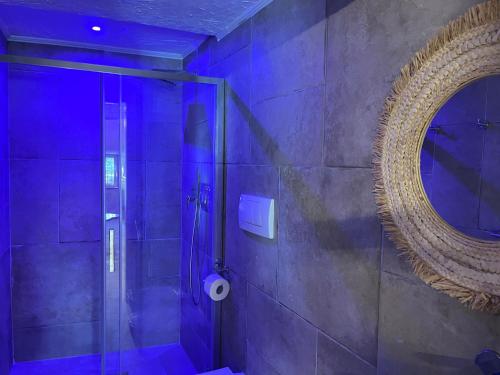 a bathroom with a shower with a mirror and purple lighting at Villa Francesca - Manfredi Homes&Villas in Monte SantʼAngelo