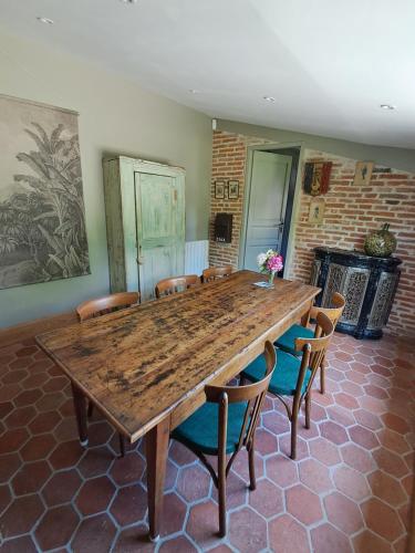 une grande table en bois et des chaises dans une pièce dans l'établissement Les Annexes, à Verdun-sur-le-Doubs
