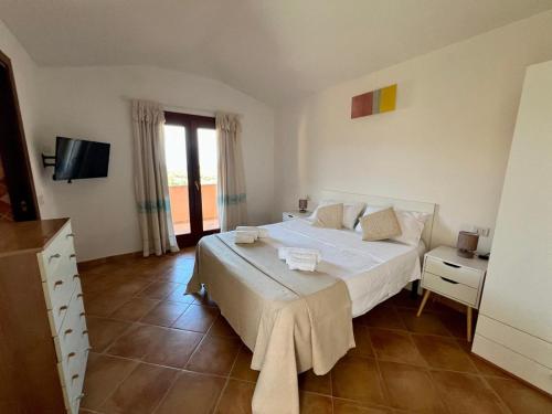 a bedroom with a large bed and a television at Villa Sunrise in Budoni
