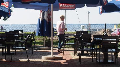 a person standing at a table under an umbrella at Tawerna Panorama in Stepnica