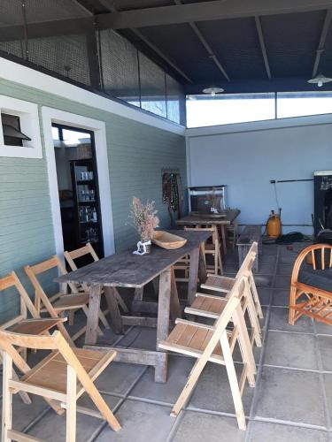 a patio with wooden tables and wooden chairs at Ita Pora Lodge in Bella Vista