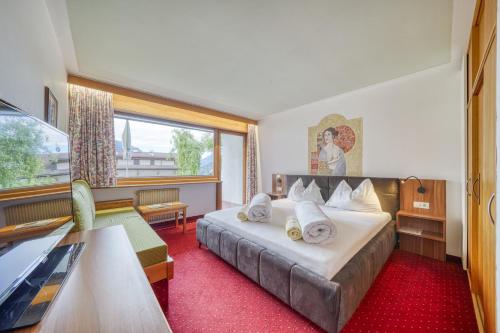 a hotel room with a bed and a window at Das Bergland - Vital & Activity in San Leonardo in Passiria