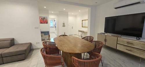a living room with a table and a flat screen tv at Modern Elegance Valletta Apartment V1 in Valletta