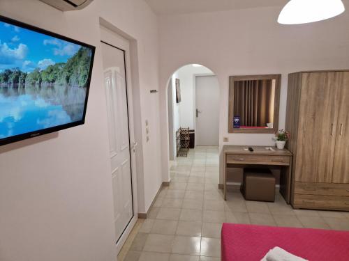 a living room with a television on a wall at Villa Maroula in Afantou
