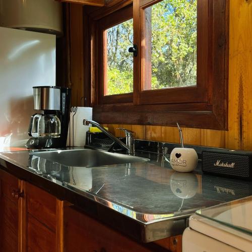 a kitchen counter with a sink and a window at Fratelli Cabañas-Apart in Rosario