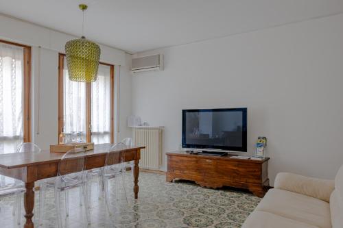 a living room with a table and a flat screen tv at Boutique Apartment Cà Tulles in Torri del Benaco
