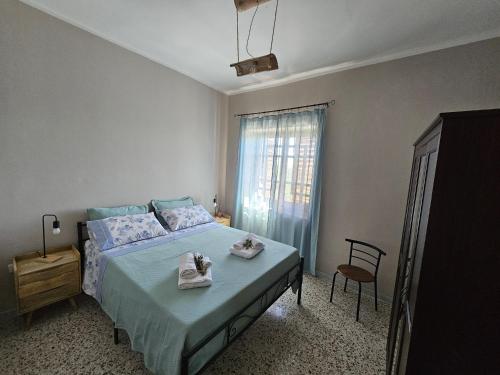 una camera da letto con un letto con due asciugamani sopra di Tenuta degli Ulivi - Dimora Contadina a Montecorvino Rovella