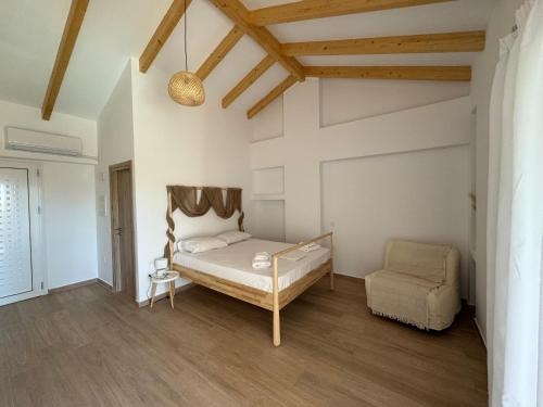 a bedroom with a bed and a chair at NikLuDin suites & studios in Laganas