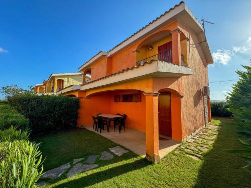 a house with a table and a balcony at Villa Arianna - Porto Pino in SantʼAnna Arresi