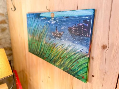 a painting of a boat in the water on a wall at Le Baki - Lac, randonnée, vue in Devesset