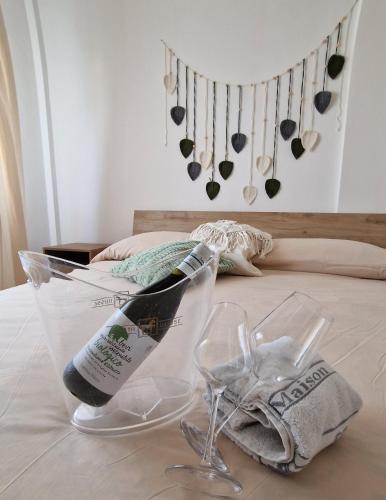 a bottle of champagne and glasses on a bed at Cerry's Apartments Fronte Mare - Seaside & Sealight in Fossacesia