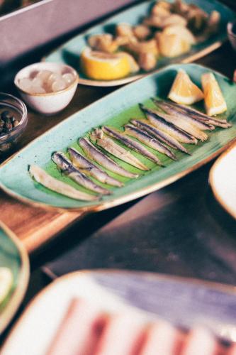 a tray of fish on a table with other foods at Hotel Fanat in Split