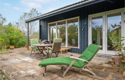 a patio with a table and chairs and a house at 3 Bedroom Stunning Home In Nykøbing Sj in Holmstrup