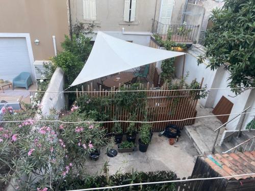 - une vue sur le jardin avec un parasol blanc dans l'établissement T2 Marseille 13008, à Marseille