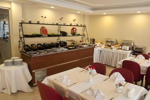 un restaurant avec des tables et des chaises blanches et un buffet dans l'établissement Abel Hotel, à Istanbul