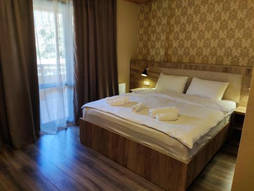 a bedroom with a large bed with two towels on it at Lagodekhi Inn in Lagodekhi