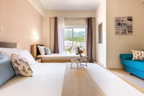 ein Hotelzimmer mit 2 Betten und einem blauen Sofa in der Unterkunft Potam'Sea Bliss 8 - Beach Front, Sun Beds & Parking in Himarë