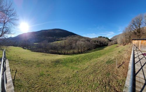 a fence in a field with a mountain in the background at Le Petit Mars in Le Vaulmier