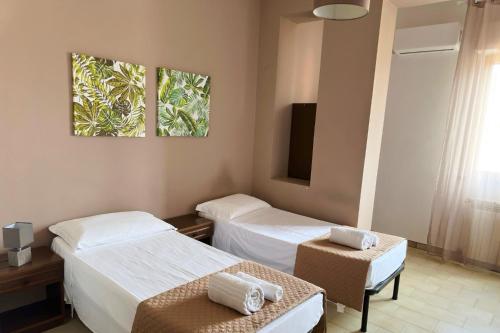 a hotel room with two beds and a tv at Poseidon Bay Residence in Milazzo