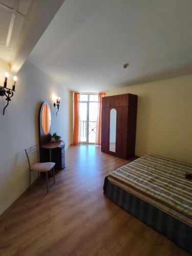 a bedroom with a bed and a table and a mirror at Elenite Sea View Apartments in Elenite