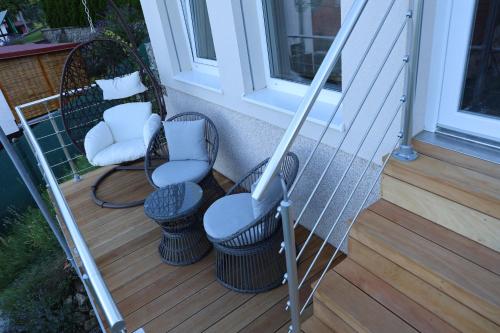 a porch with two chairs and two stools at Vinný sklep Klentnice in Klentnice