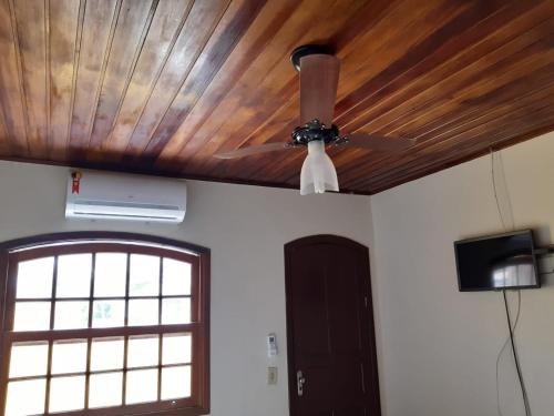 a ceiling fan and a television in a room at Gil's suites in Paraty
