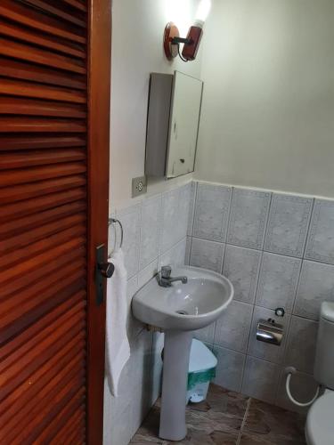 a bathroom with a sink and a mirror at Gil's suites in Paraty