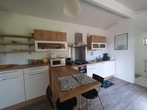 une cuisine avec des armoires blanches et une table en bois dans l'établissement Studio avec jardin-Proche LDLC-Groupama Stadium-Eurexpo-métro, à Vaulx-en-Velin