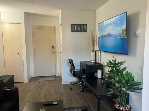 an office with a desk and a tv on a wall at Entire Apartment Prime Downtown location Free underground Parking in Calgary