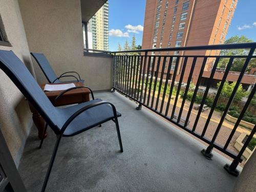 a balcony with two chairs and a view of a building at Entire Apartment Prime Downtown location Free underground Parking in Calgary